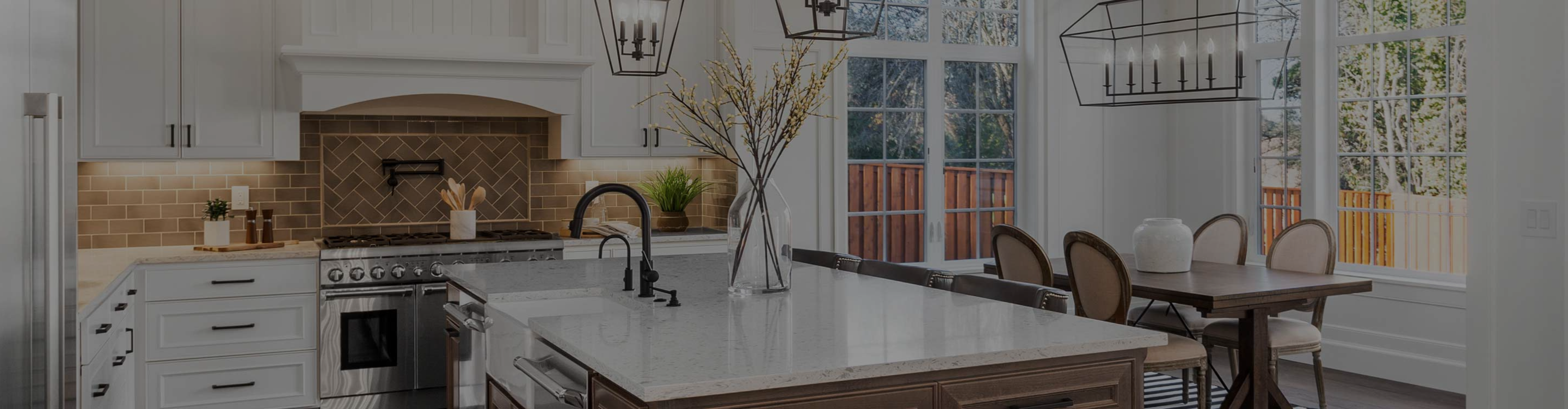 Modern kitchen and dining area with white cabinets, marble countertops, stainless steel appliances, dark wood table, and large windows, featuring a clean, airy "Modern Farmhouse" design.