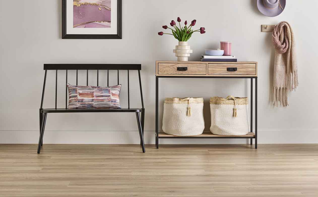 Laminate flooring in hallway with bench and table